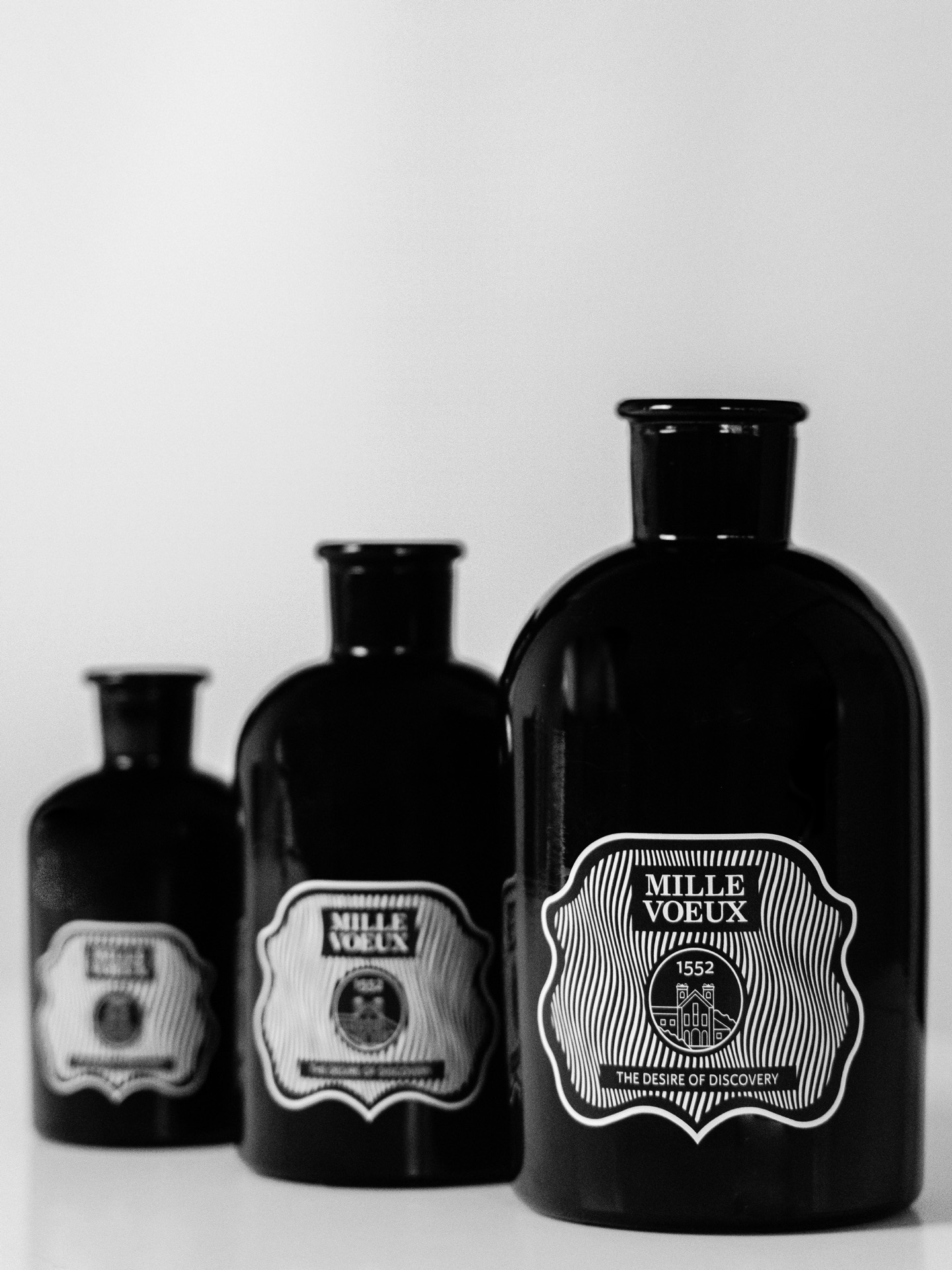 The optical-illusion label across three bottle sizes