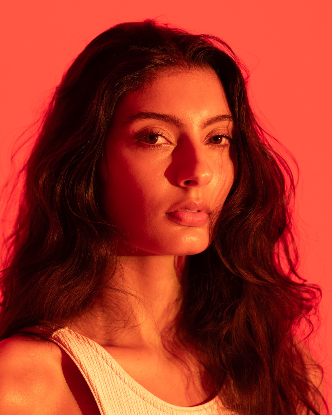 Red-gel beauty portrait, light raking across the face